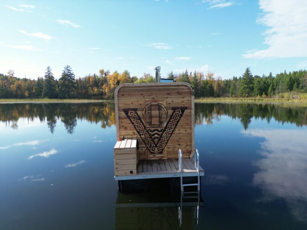 Valhallan floating sauna with carved V logo floating on a calm Minnesota lake