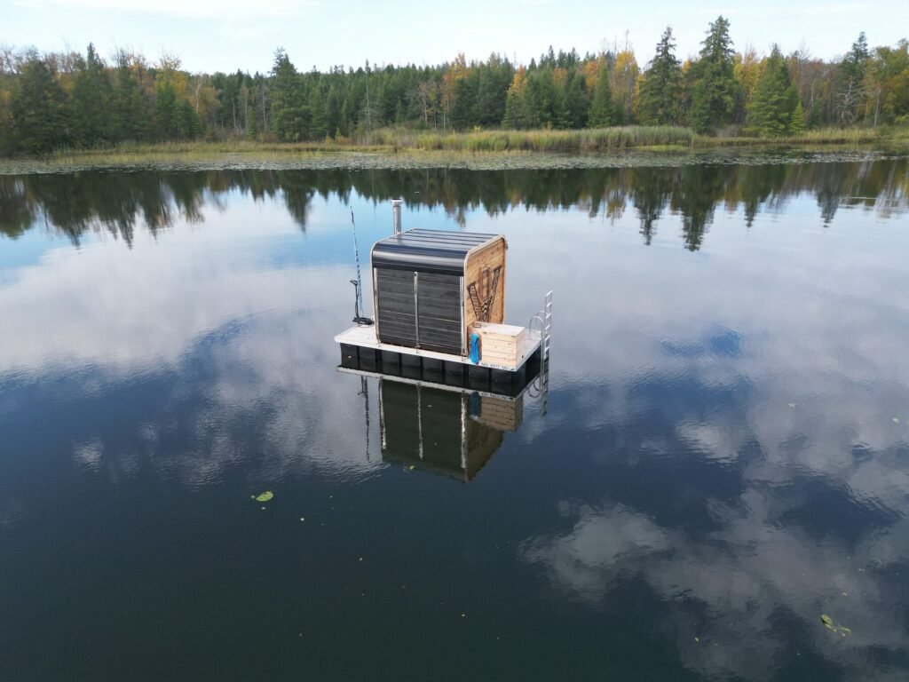 Valhallan floating sauna on open water with a forest shoreline